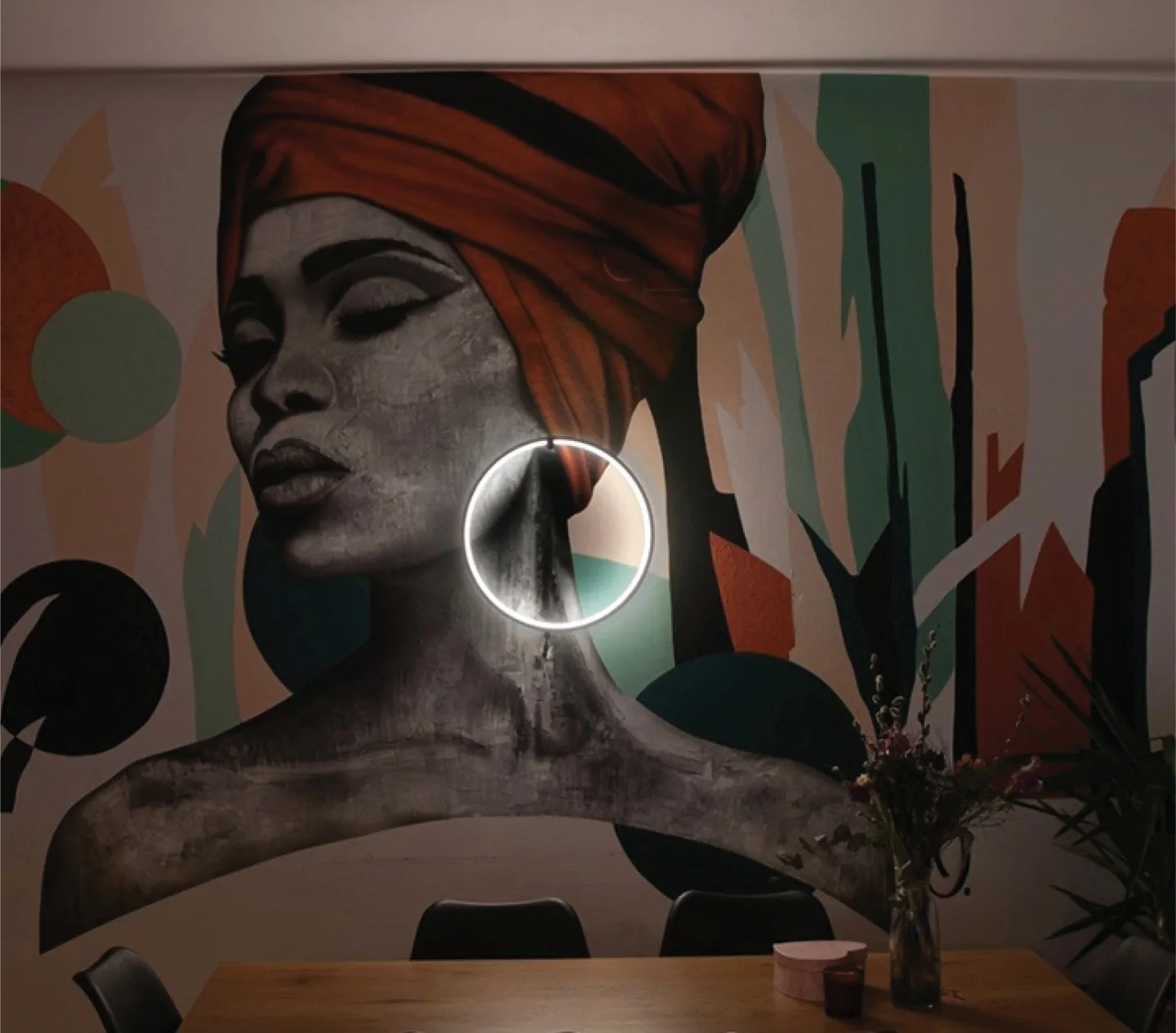Portrait mural in evening light with its circular lamp switched on.