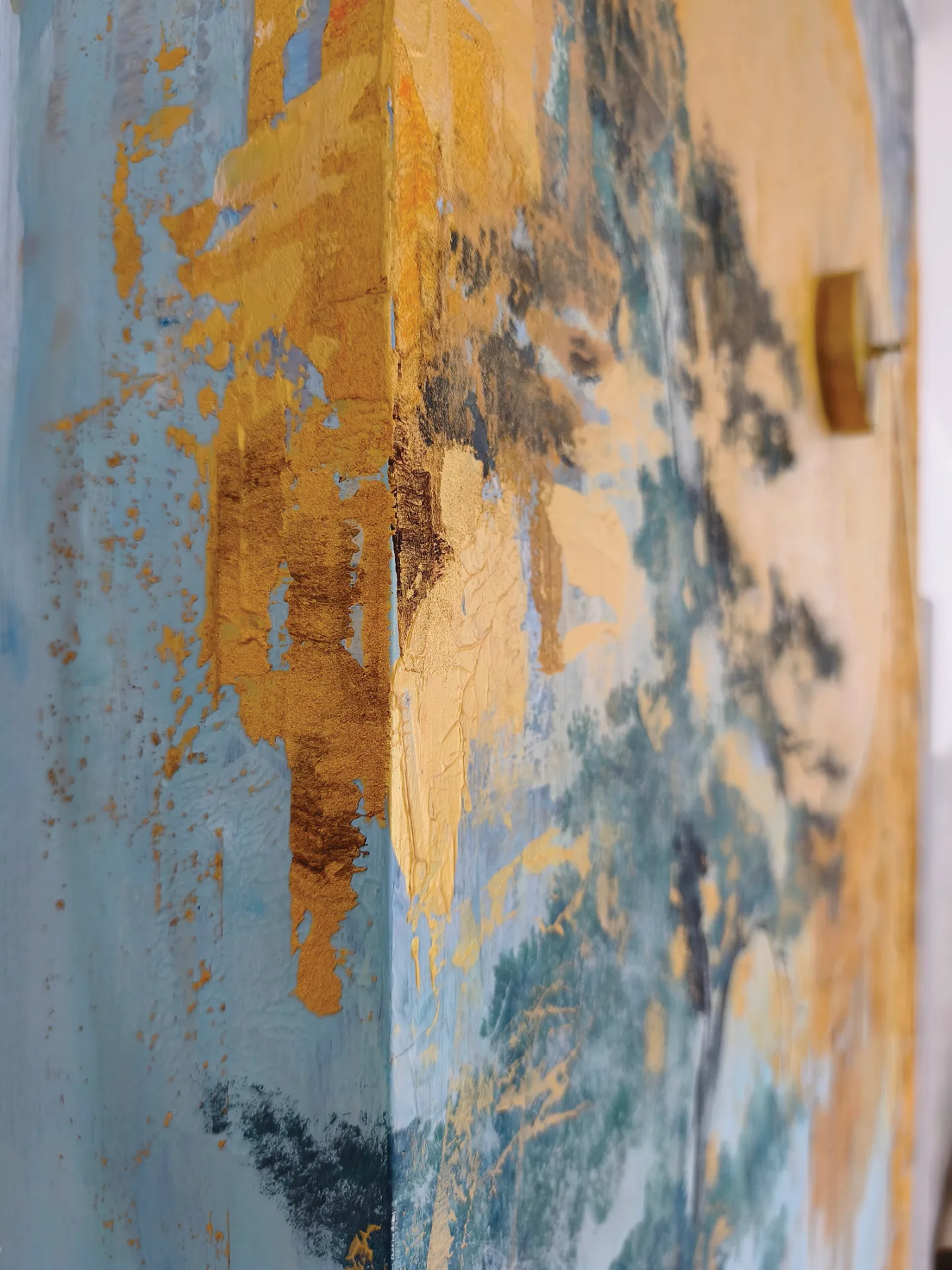 Blue, grey and gold paint layers in the apartment mural.