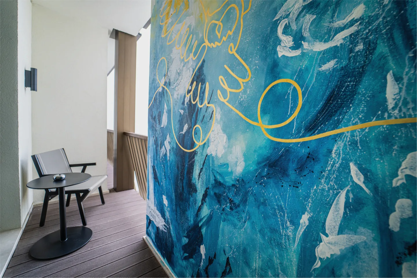 Close view of the blue and gold mural beside terrace seating.
