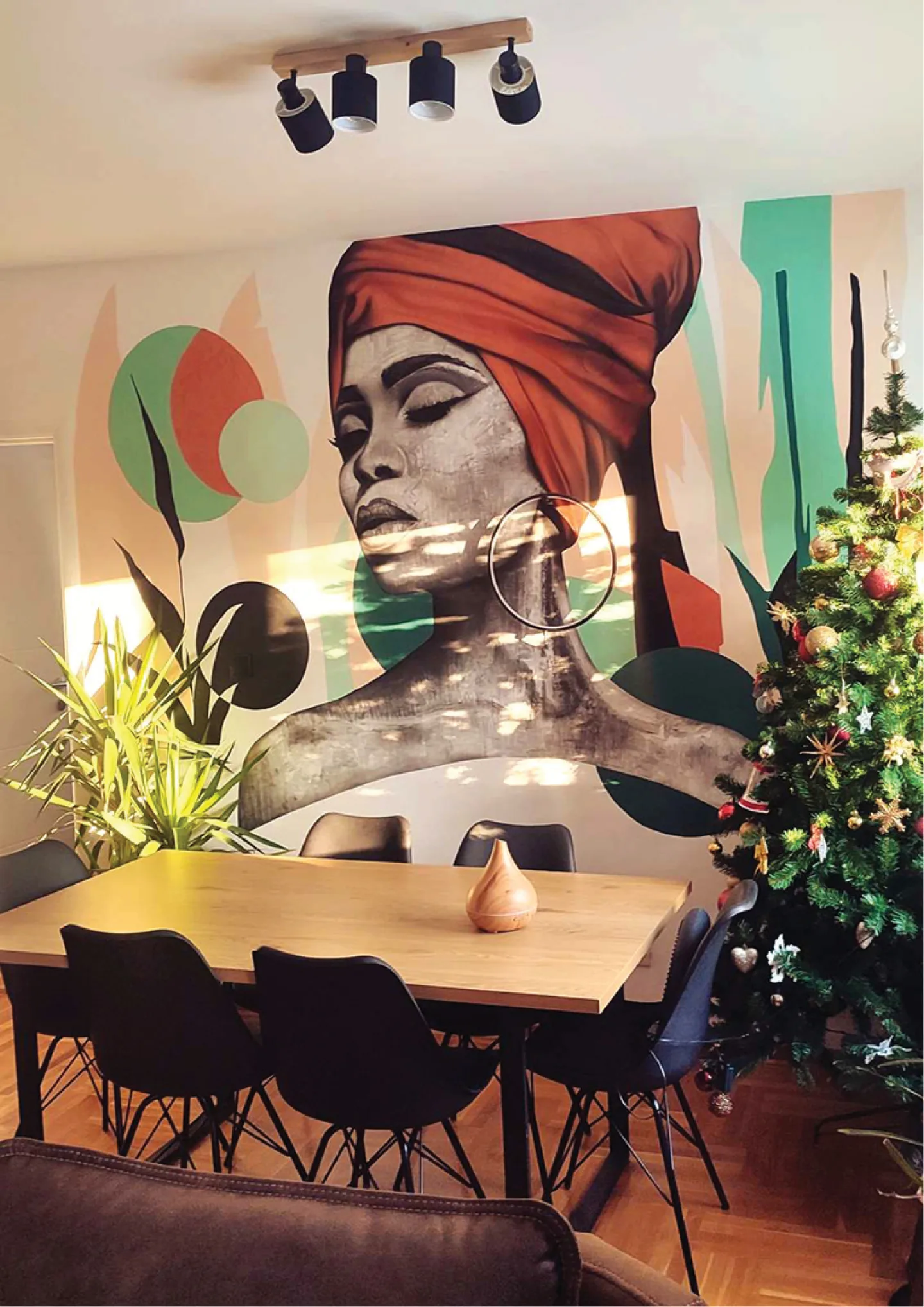 Dining area with the portrait mural and circular light.