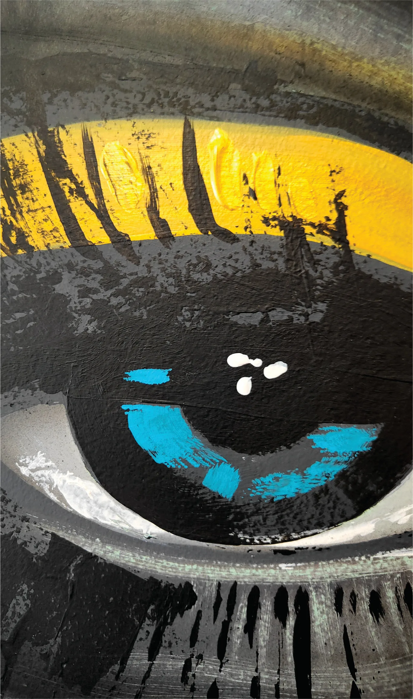 Detail of a painted eye with blue and gold accents.