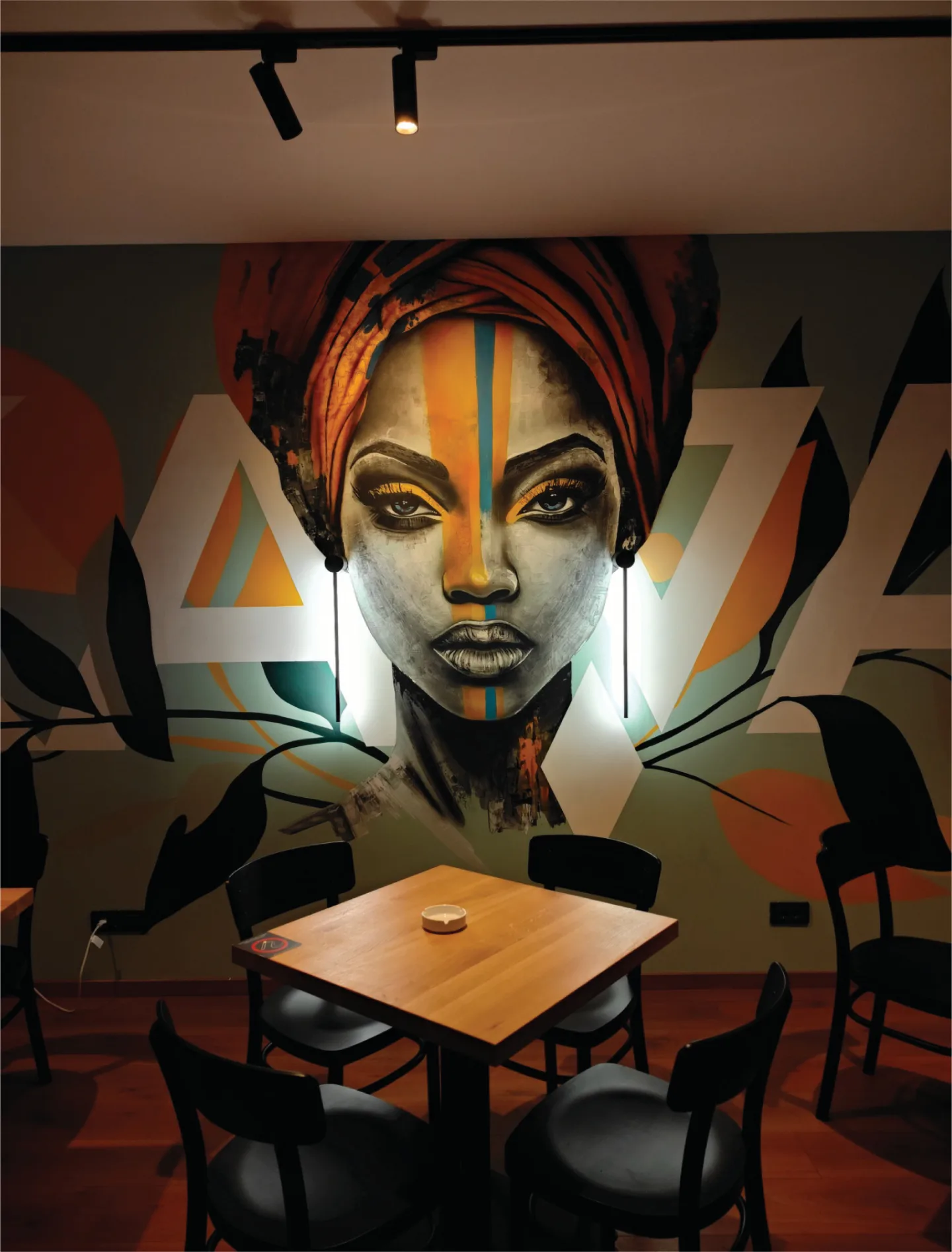 Portrait mural with integrated vertical lighting behind a café table at Kawai.
