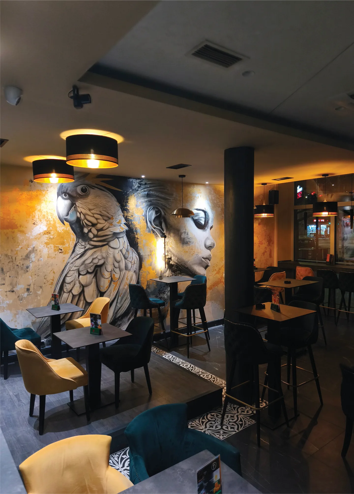 Café Bellucci interior with a cockatoo and portrait mural in grey and gold.