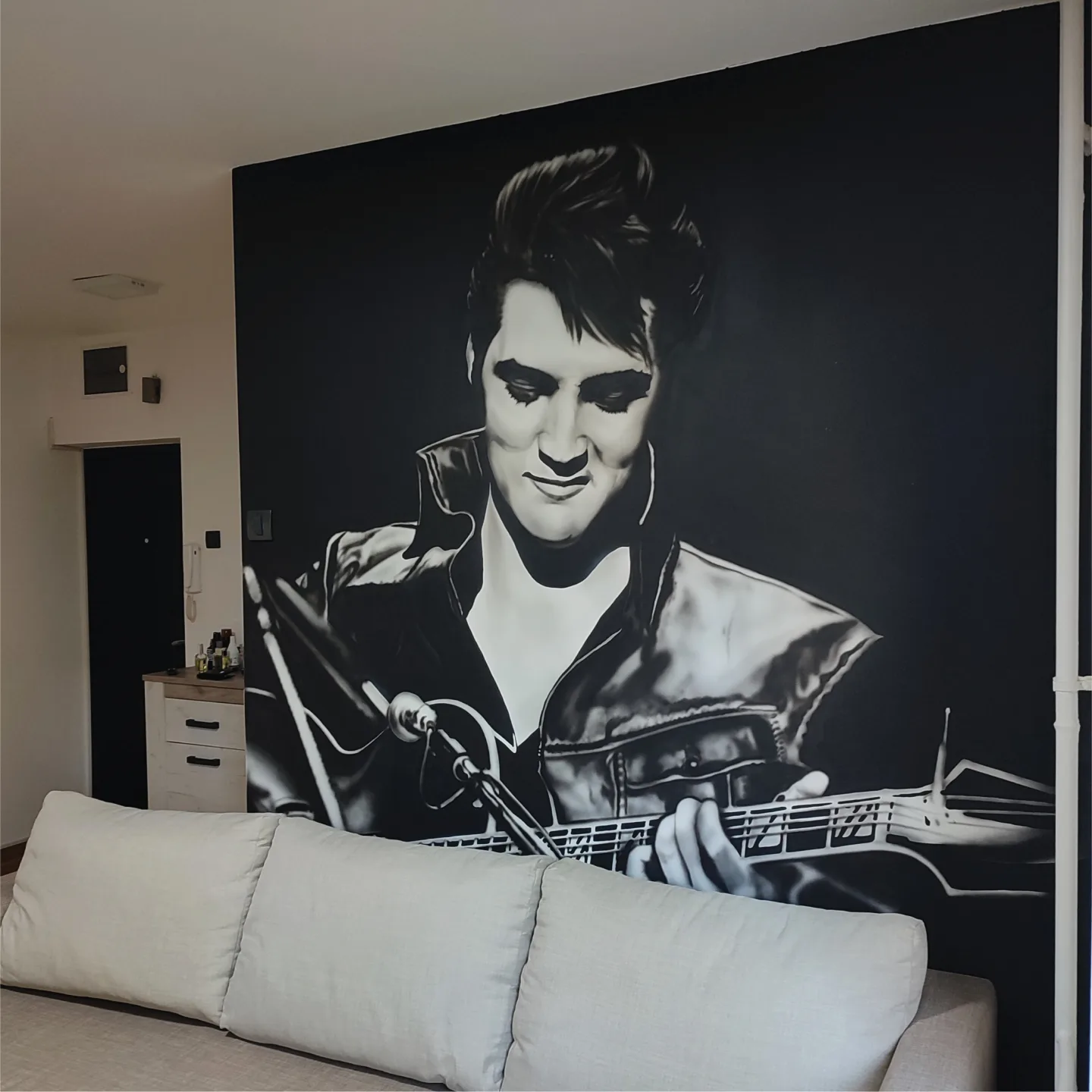 Angled view of the Elvis Presley mural above the sofa.