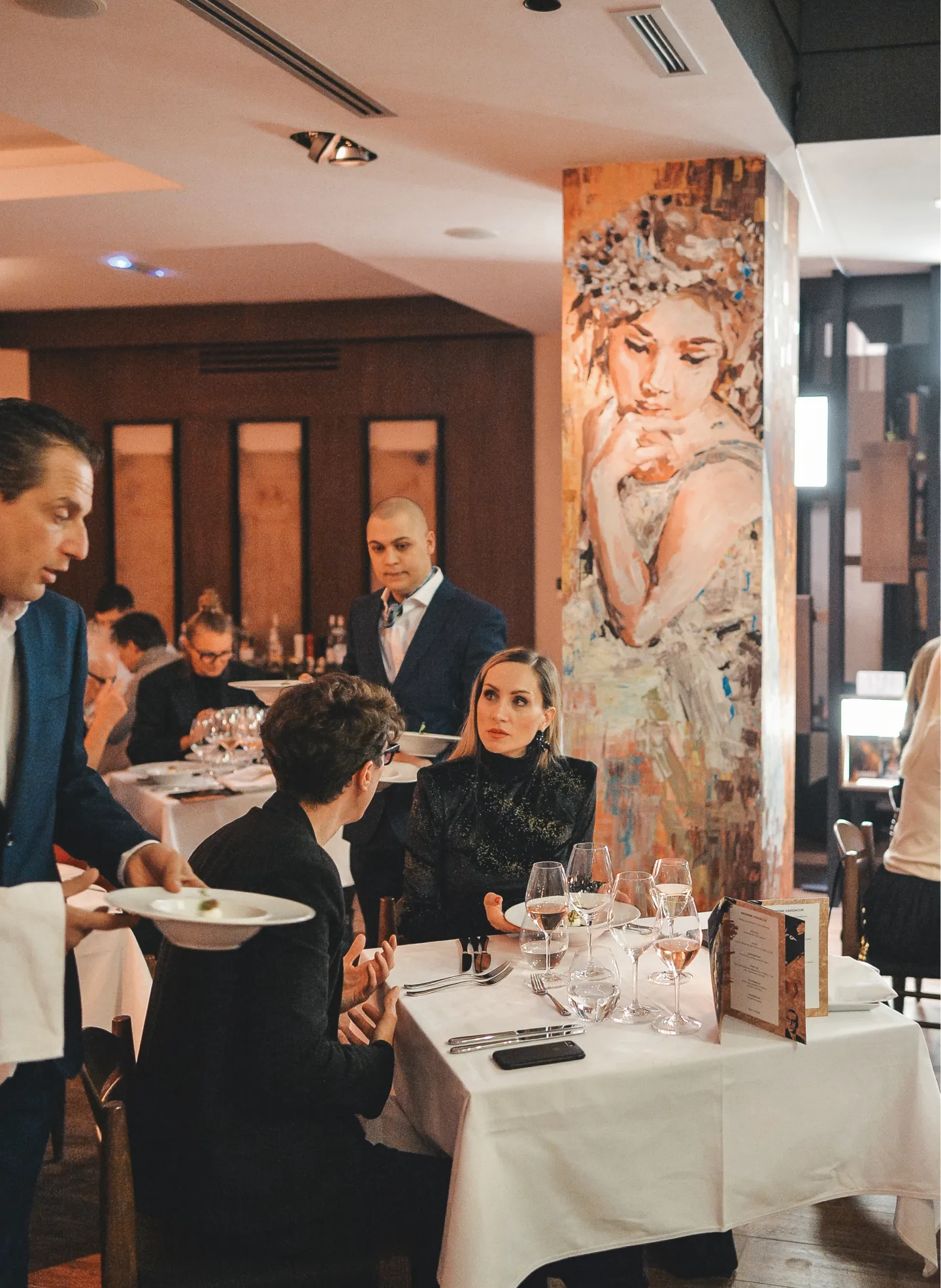 Dining room at Mudra Cuisine with a portrait painted on the central pillar.