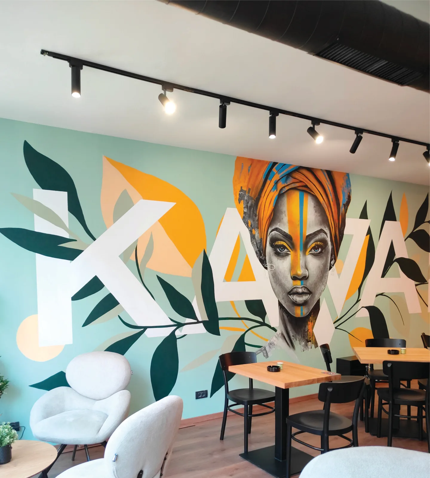 Café seating in front of the portrait mural at Kawai.